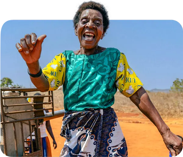 African woman dances next to fixed Afridev water pump